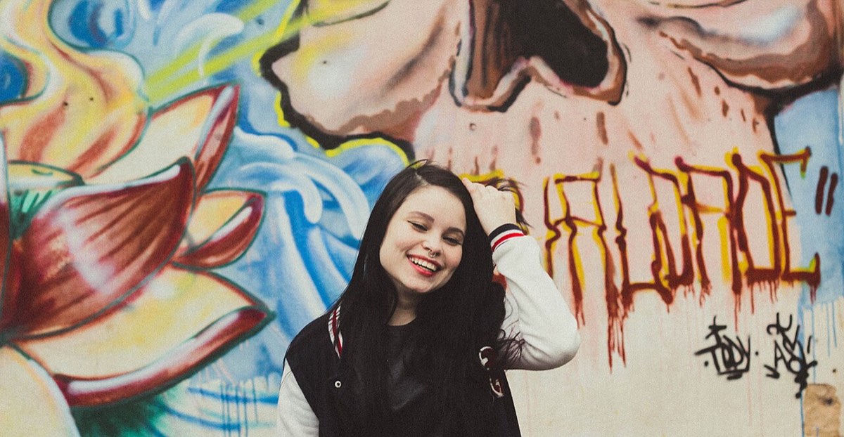 Laughing in front of graffiti: funny bars work best delivered dead serious