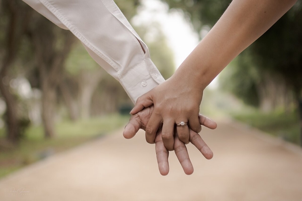 Two hands linked on a quiet path