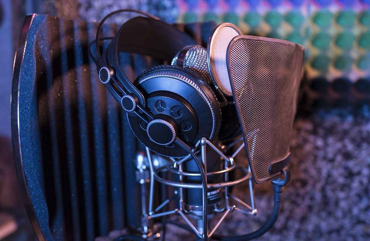 A studio mic and headphones: songs are audio-only